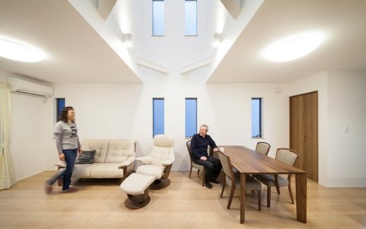 個室を1階と3階にまとめ、2階にトップライトから採光できる20帖リビングを実現